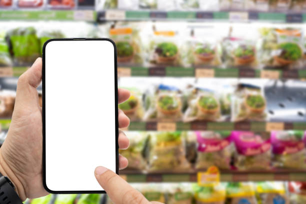 istock Hand holding blank screen smartphone for copy space on blurred Miscellaneous Product shelf. e-commerce app shopping mockup. social media, payment and shopping online concept. 2156126440