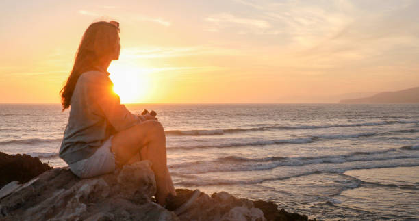istock Young woman looks across ocean with binoculars 2156127840