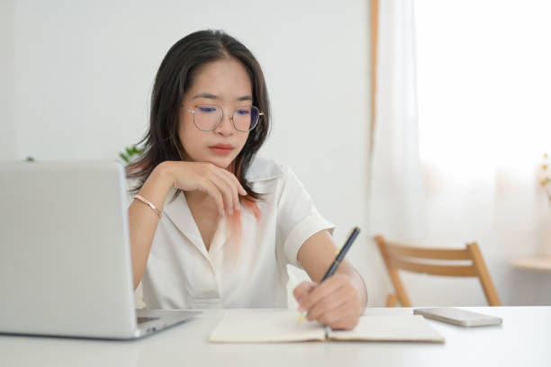 istock A focused young Asian female student doing homework or studying online in a coffee shop. 2156128370