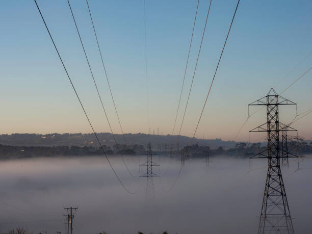 Electric wires against the background of the sky with the sun.
