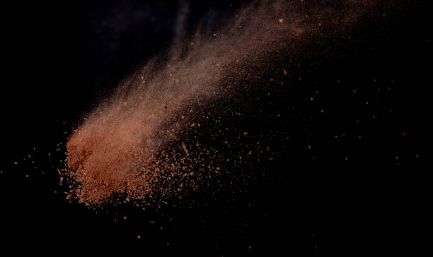 istock Brick Sand flying explosion,  Abstract cloud fly. Orange colored sand splash throwing in air on black background 2156129311