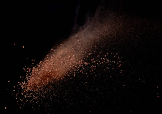 istock Brick Sand flying explosion,  Abstract cloud fly. Orange colored sand splash throwing in air on black background 2156129316
