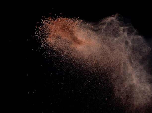 istock Brick Sand flying explosion,  Abstract cloud fly. Orange colored sand splash throwing in air on black background 2156129317