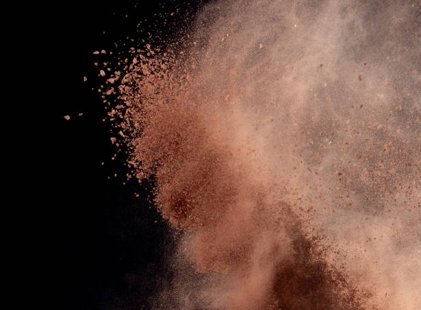 istock Brick Sand flying explosion,  Abstract cloud fly. Orange colored sand splash throwing in air on black background 2156129324