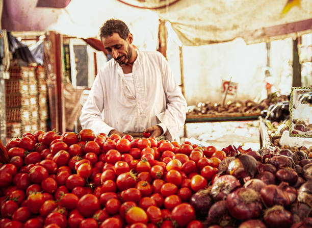 The people at food market with bananas, tomatoes, oranges, lettuce, and other fruits and vegetables, at bazaar of Ramallah, the capital of Palestinian West Bank.