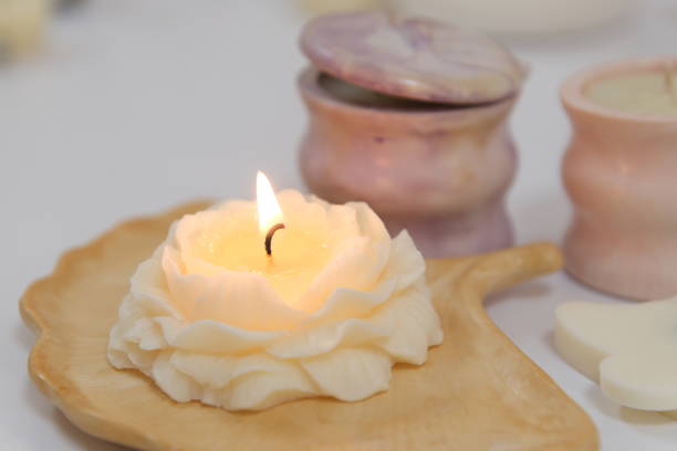 istock The lighter ignites a candle, light a candle hand with match sets fire to scented pink wax candle on a gray background 2156130450