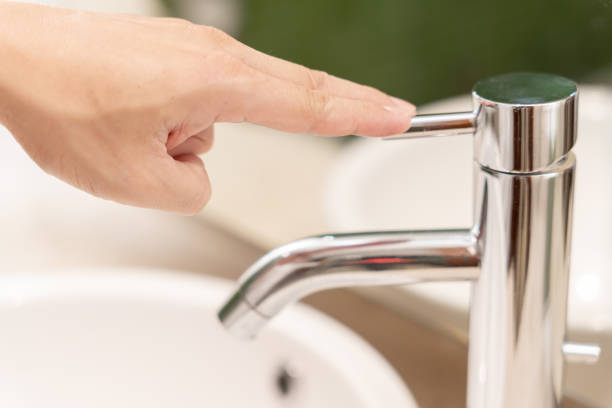 istock Save water. Man keeps turning off the running water in the bathroom to protect environment. Greening planet, reduce global warming, Save world, life, future, risk energy, crisis , water day. 2156137224