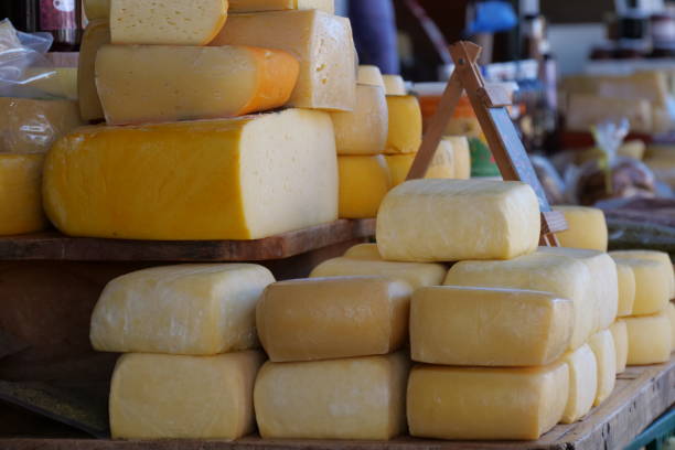 istock Big blocks of Cheese stacked on a table in a market 2156142492