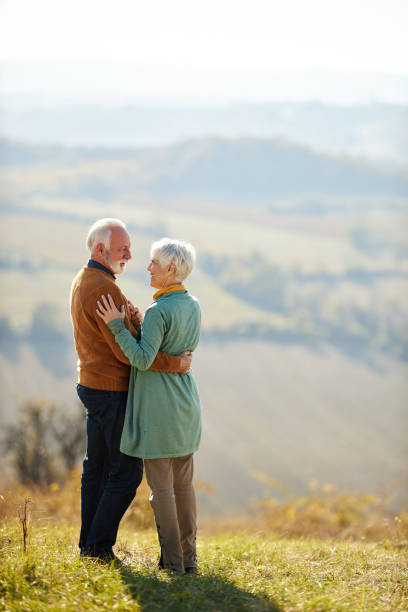 istock Happy senior couple talking while enjoying on a hill in autumn day. 2156145764