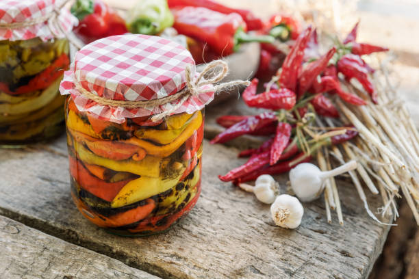 istock Roasted peppers marinated in glass jars on wooden table close up 2156145938