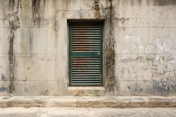 istock Small old green rusty door in a dirty concrete wall 2156146089