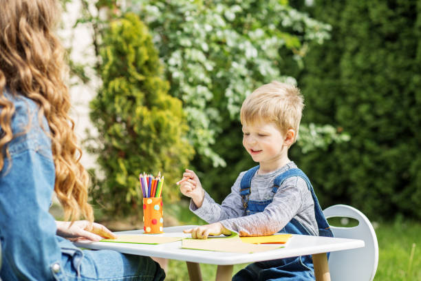 istock Happy child drawing with mother outdoors. Early years. Baby development. 2156147624