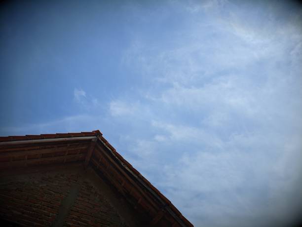 Low angle of house roof with sky background