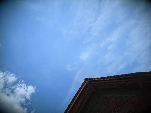 Low angle of house roof with sky background