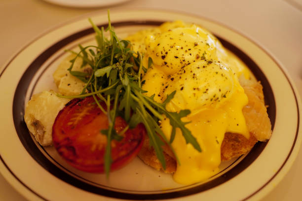 istock Close up eggs Benedict and bacon on toast served with green salad 2156148458
