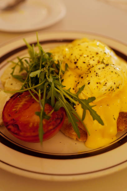 istock Close up eggs Benedict and bacon on toast served with green salad 2156148461