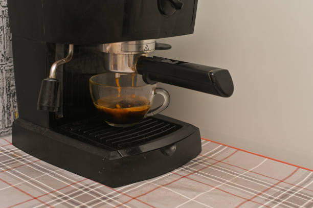 istock A coffee maker pours coffee into a glass cup 2156148799