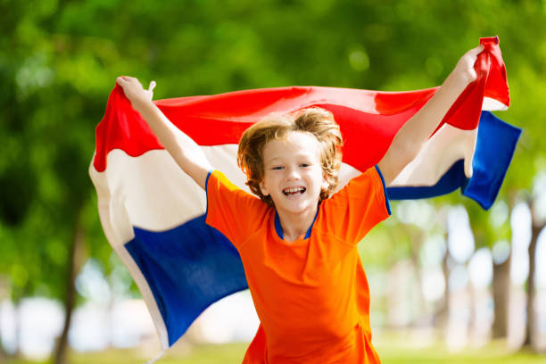 istock Netherlands team supporter. Dutch kid with flag. 2156149655