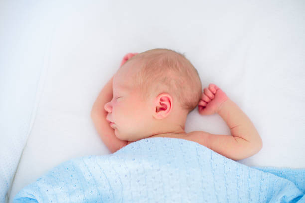 istock Little baby on white bed 2156150585