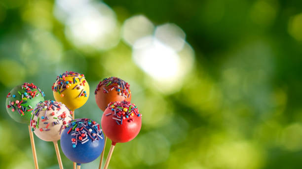 A Delightful Display of Colorful Cake Pops Against a Lush Green Background