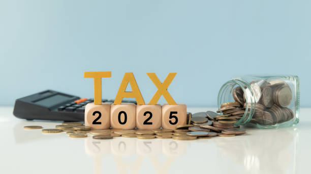 Business and tax concept. Wooden blocks spelling out TAX 2025, surrounded by coins and a calculator. Tax deduction planning. Financial research, government taxes and calculation tax return. concepto empresarial y fiscal. bloques de madera que deletrean tax 2025, rodeados de monedas y una calculadora. planificación de deducciones fiscales. investigación financiera, impuestos gubernamentales y cálculo de la declaración de impuestos.