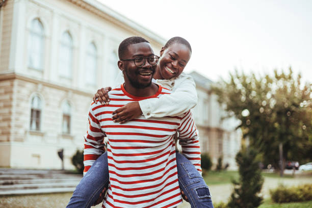 istock Joyful Black Student Couple Enjoying Piggyback Ride 2156154124