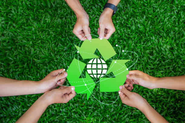 istock Zero waste concept. The picture shows three hands holding a green recycling symbol with a globe in the center. Reuse Reduce Recycle. CSR. Environmental sustainability. volunteer, Unity. ESG. 2156156615