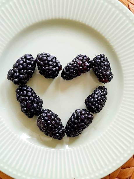 Blackberries on white plate in heart shape
