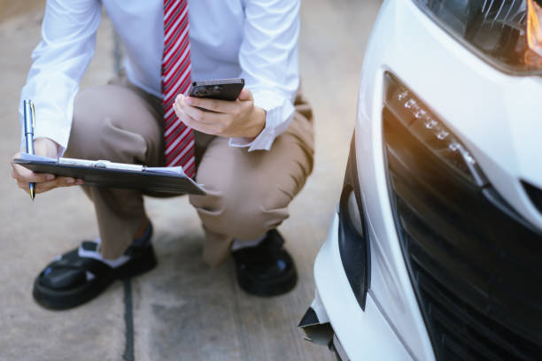 istock Insurance agent writing on clipboard while examining car after accident claim being assessed and processed 2156156754