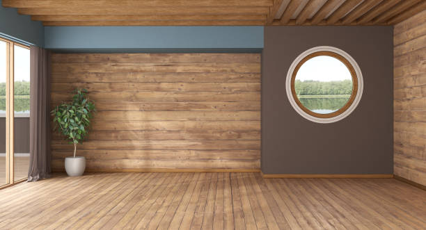 An empty room bathed in natural light from large, expansive windows. The room features glossy wooden flooring, white walls, and modern architectural design. This setting presents the perfect opportunity for decoration and personal touch.
