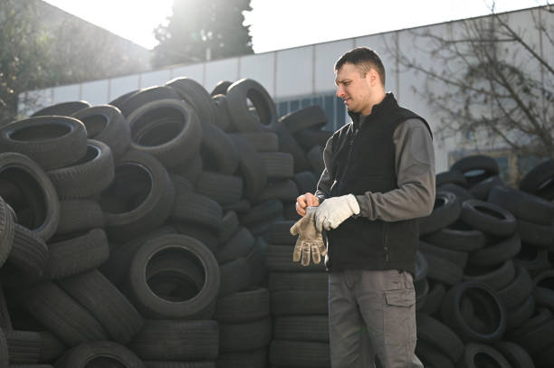 istock man working at recycling center with rubber tires. 2156162264