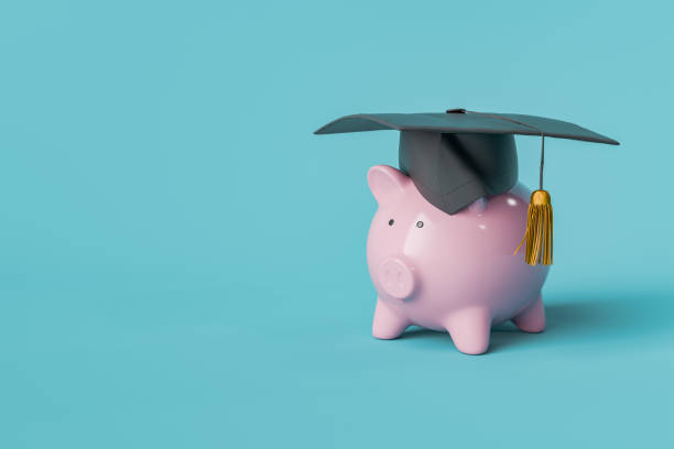 istock Piggy Bank with Graduation Cap on Blue Background with Copy Space 2156165224