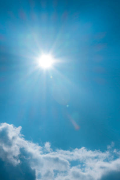Sky. Heaven background. Cloud and bright sun with long rays on a bright blue sky.Bright sunny weather background.Beautiful natural background