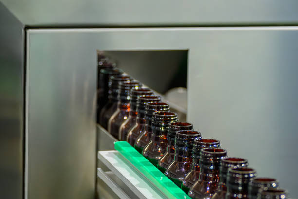 The  empty drug  bottles  on the conveyor belt for filling process. The hi-technology of drinking water filling process.