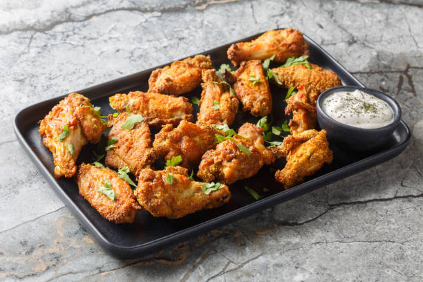istock Spicy crispy baked chicken wings breaded with curry close-up in a plate. Horizontal 2156167977