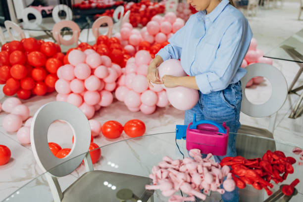 istock An unrecognizable decorator ties balloons after inflating them using a balloon pump. She is making birthday decorations at the restaurant 2156168253