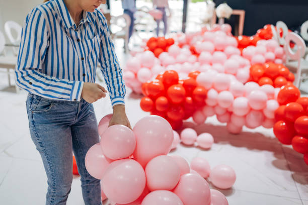 istock Close-up of the decorator's hands tying balloons to make a column 2156168355