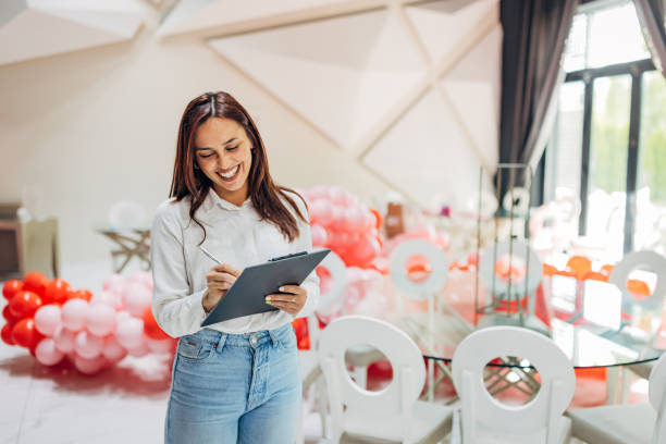 istock A female party planner crosses tasks off her to-do list while decorating a restaurant for a party 2156168422