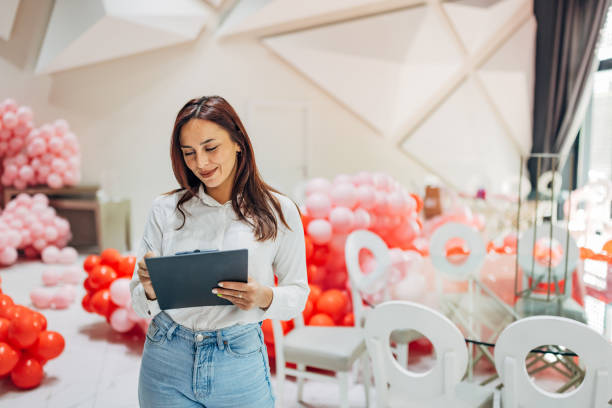 istock A female party organizer crosses tasks off her to-do list while decorating a restaurant for a party 2156168989