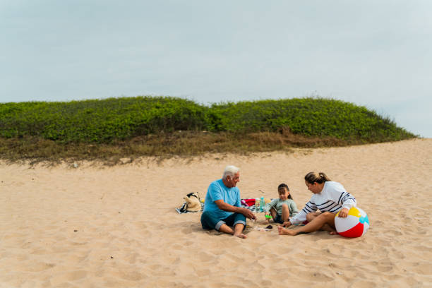 istock Family talking and playing with sand on the beach 2156169735