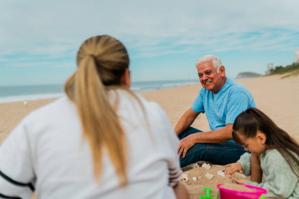 istock Family playing sand and talking at beach 2156169890
