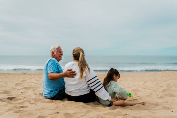 istock Family playing sand and talking at beach 2156169915