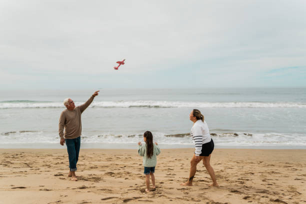 istock Family playing with the toy plane at beach 2156170019