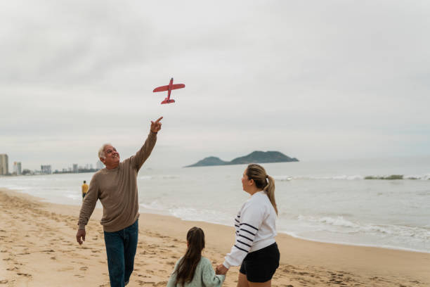 istock Family playing with the toy plane at beach 2156170039