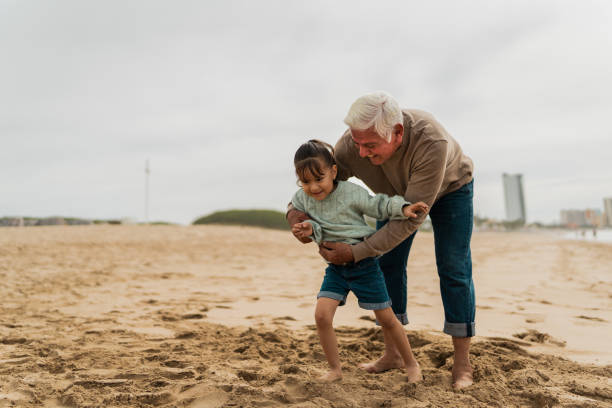 istock Senior embracing granddaughter at beach 2156170054