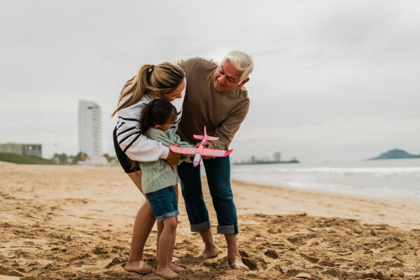 istock Family playing with the toy plane at beach 2156170133