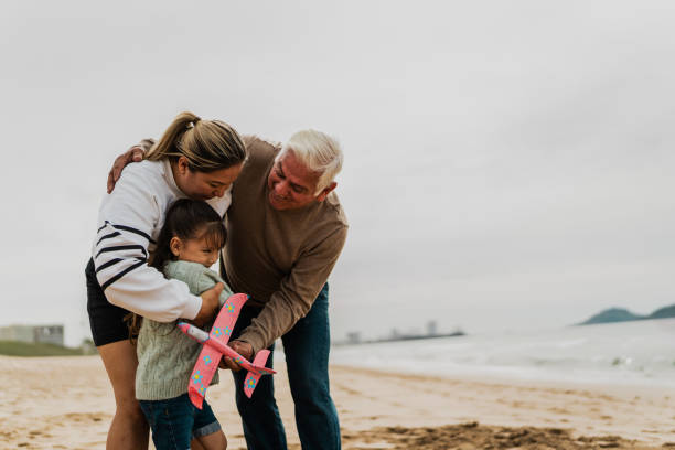 istock Family playing with the toy plane at beach 2156170135