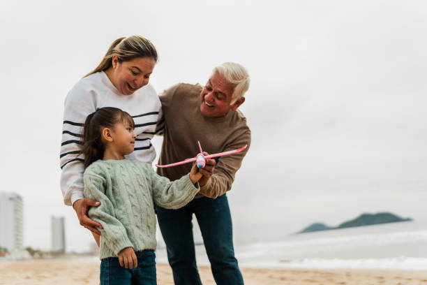 istock Family playing with the toy plane at beach 2156170136
