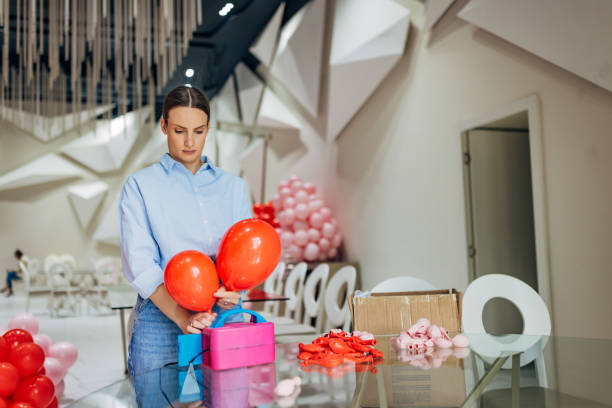 istock Female party decorator and event planner arranging decorations for a party 2156170195