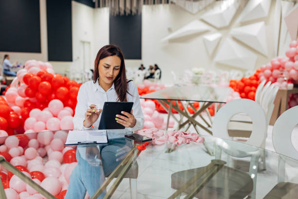 istock Female decorator is sitting at a table in a restaurant using a digital tablet 2156170370
